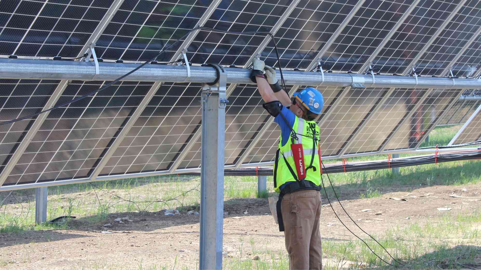 Electrician performing wiring work on solar panels at the Paddock Solar Project near Beloit Wisconsin.