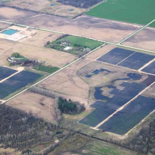 Aerial view of the Albany Solar project in Green County, Wisconsin, showing multiple solar panel arrays spread across open farmland.