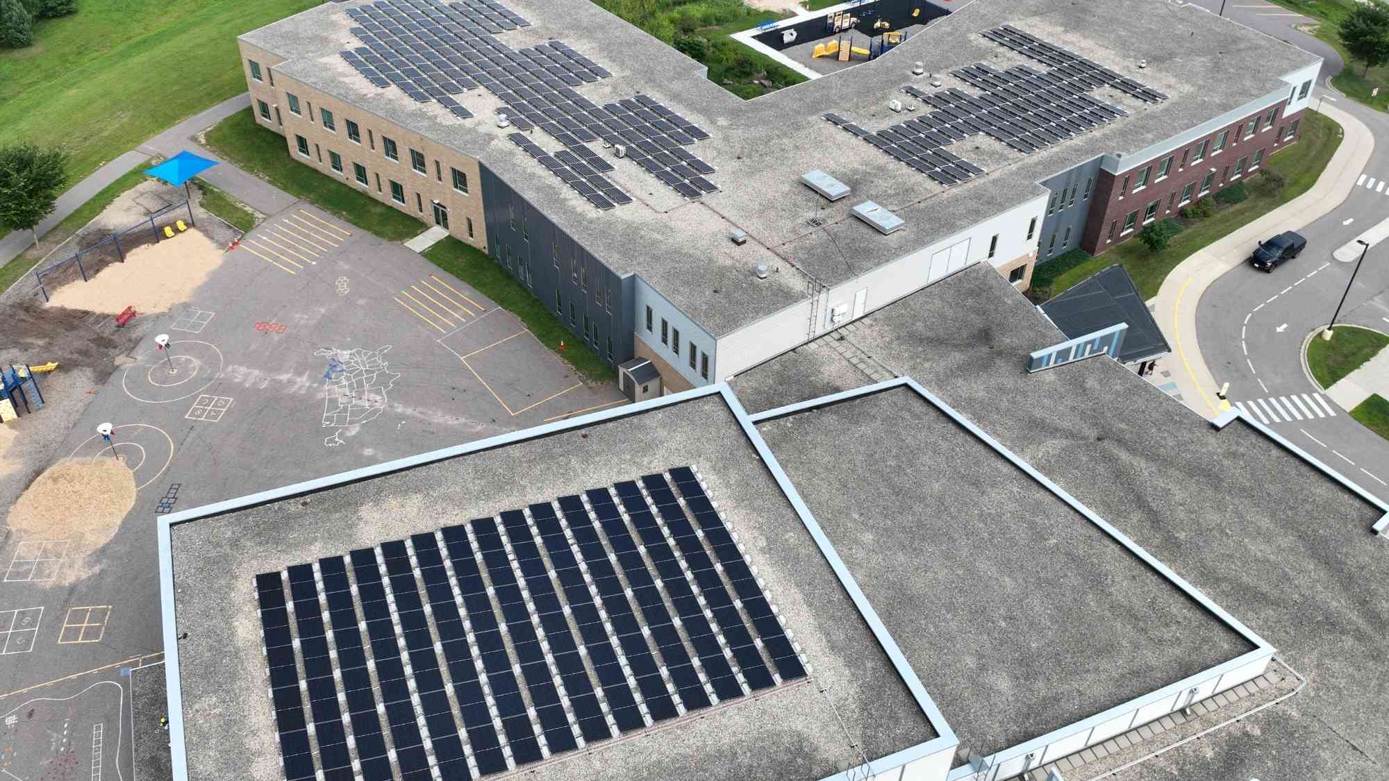Aerial view of rooftop solar arrays installed on multiple sections of the Bridges Elementary School campus.