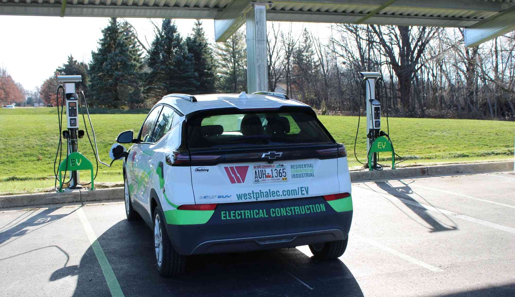 Electric vehicle charging at dual-pedestal EV stations located beneath the solar canopy at IBEW Local 494.