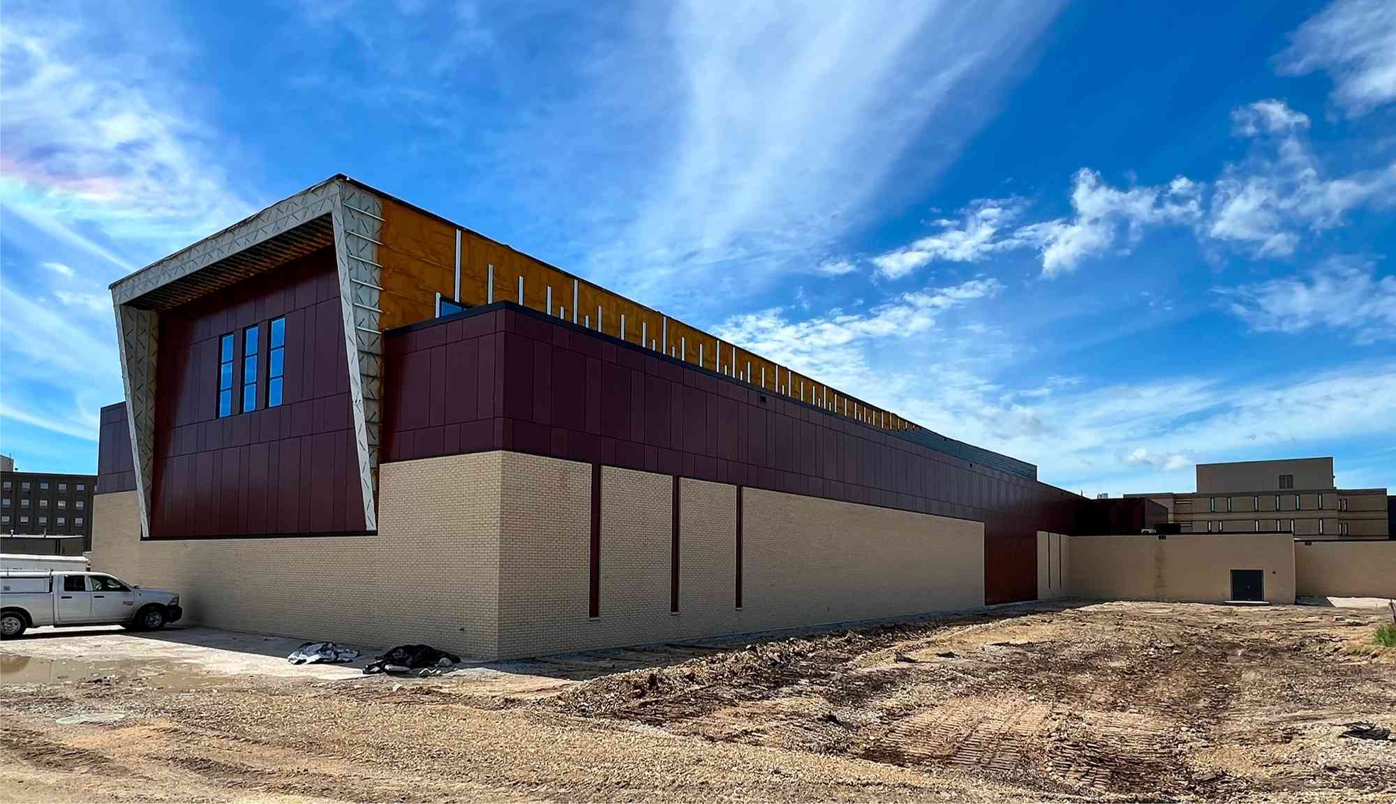 Exterior view of a newly constructed institutional building with modern facade and surrounding construction area.