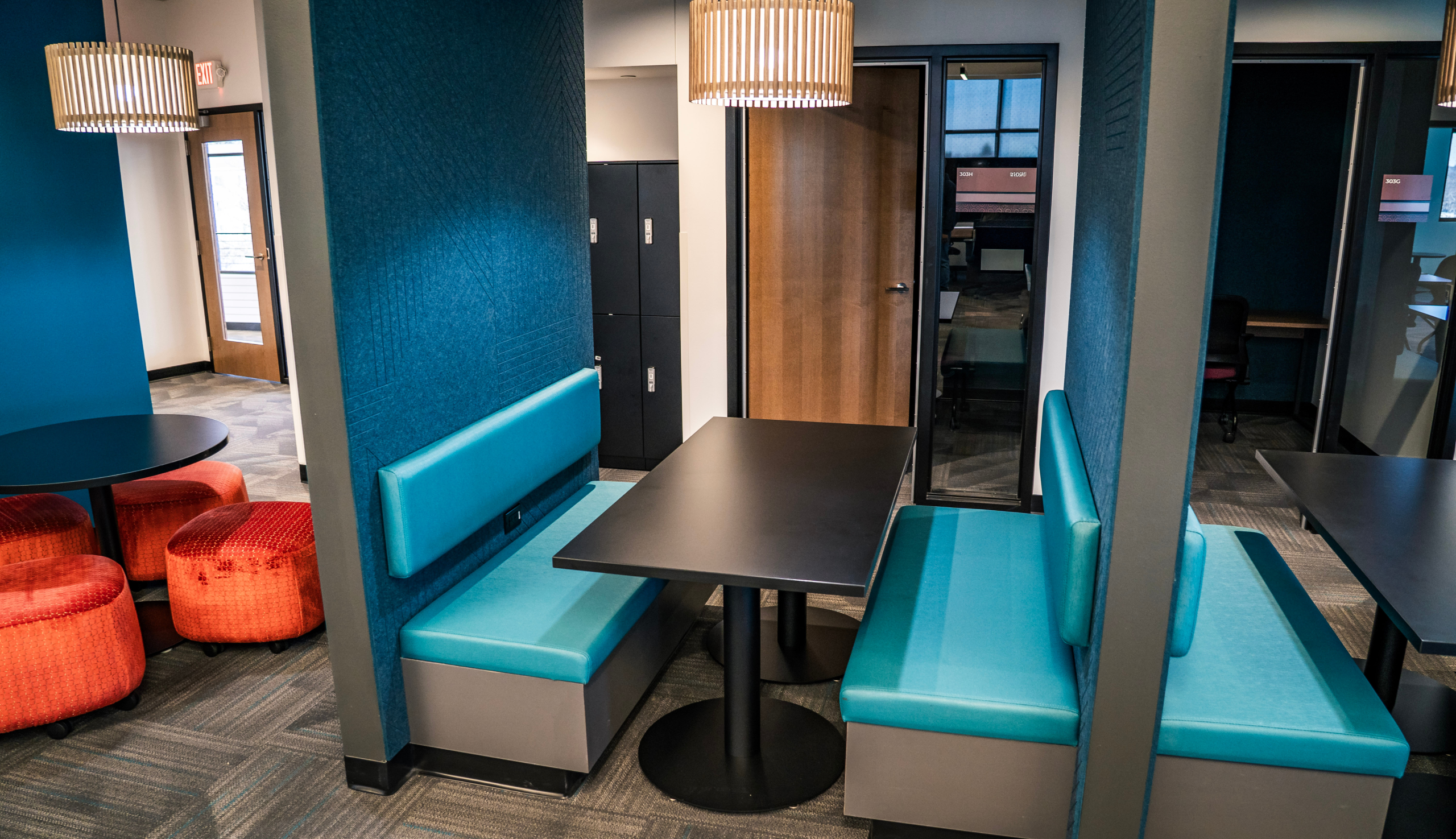 Collaborative workspace seating inside The Center for Black Excellence and Culture featuring modern booths, pendant lighting, and vibrant interior design.